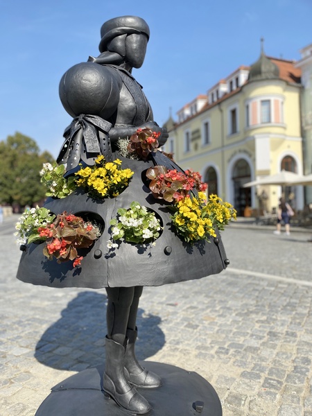 Květinová socha ženy v kroji ozdobila náměstí