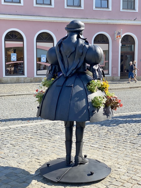 Květinová socha ženy v kroji ozdobila náměstí